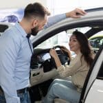 comprar-carro-usado-empregado-de-concessionaria-de-carros-entregando-as-chaves-de-um-carro-usado-para-uma-jovem