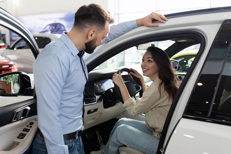 comprar-carro-usado-empregado-de-concessionaria-de-carros-entregando-as-chaves-de-um-carro-usado-para-uma-jovem