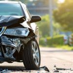 Carro com a frente amassada após uma colisão, evidenciando a necessidade de reparo na longarina devido ao impacto.